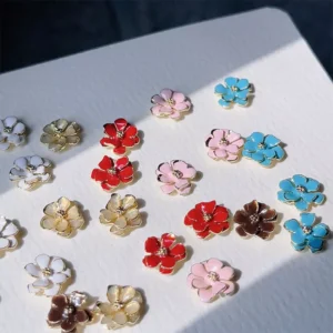 Sunlit close-up of colorful metal flower nail decorations arranged on paper
