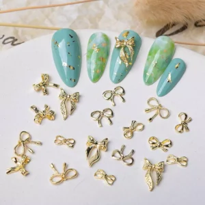 Gold bow nail charms with rhinestone details and classic outlines