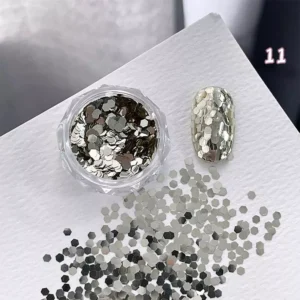 Metallic gold hexagon glitter scattered beside full-coverage glitter nail tip