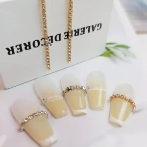 Golden rhinestone nail chains paired with gradient nail tips for display