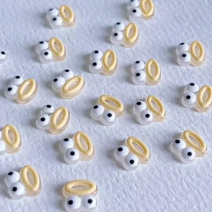 Beige funny eye nail charms with 3D effect on white background