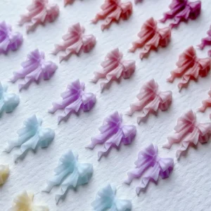 Repetitive layout of 3D pastel bow charms in gradient colors