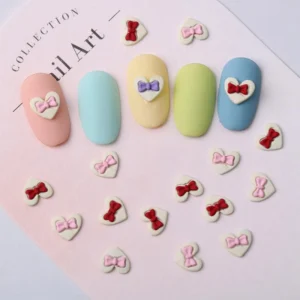 Sweetheart nail decorations in pink and red bow combos spread on a pastel backdrop