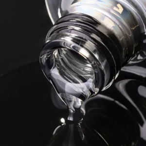 Clear gel dripping from bottle showing viscosity of professional nail gel polish
