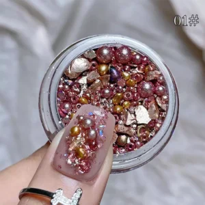 Close-up of rose gold holographic nail glitter flakes with pearls and shimmer shards