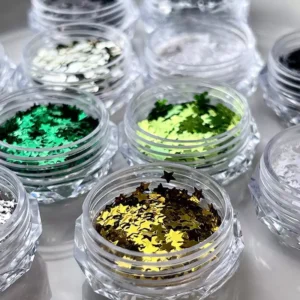 Gold and green star glitter in clear acrylic nail art containers