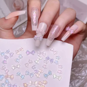 Iridescent bow nail charms on long glossy nails with pearl finish