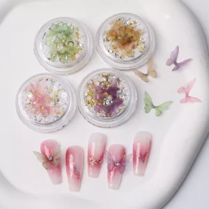 Iridescent butterfly nail charms in gold glitter jars with floral nail art