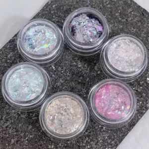 Close-up of chrome aurora nail glitter jars in mixed holographic colors