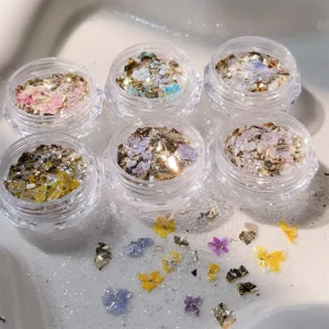 Iridescent nail glitter jars with dried flower and gold foil mix