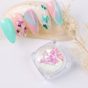White iridescent heart sequins in jar with pastel nails on shell display
