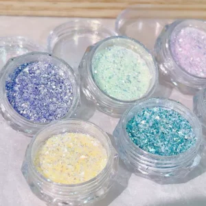 Pastel iridescent nail glitter jars in blue, mint, lilac, and yellow