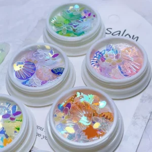 Close-up of holographic nail sequins in shell and petal shapes