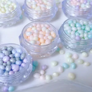 Mixed dopamine jelly pebble nail charms with pastel shine spilled across surface