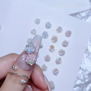 Hand with nail decorated using iridescent transparent rose charms