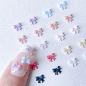 Close-up of 3D pastel bow nail decorations in pink, blue, and purple