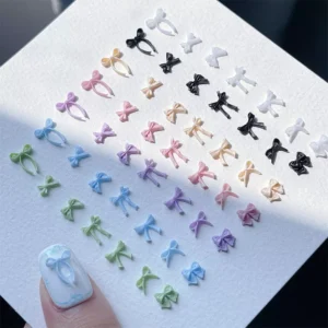 Diagonal layout of pastel bow nail charms under natural light