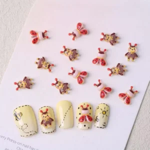 3D ladybug and girl bee resin nail charms displayed on yellow nail tips