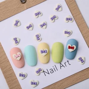 Lavender bow nail hearts applied on pastel-colored tips with packaging card background