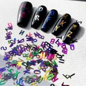 Black base nails decorated with holographic alphabet nail sequins