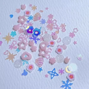 Scattered nail glitter mix with stars, shells, and flowers