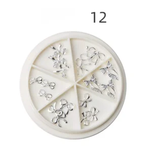 Silver glitter and polished bow nail charms organized in compartment tray