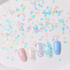 Pastel macaron flower nail sequins arranged on a plate with nail art display