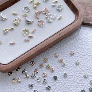 Decorative nail charms scattered on textured white background with close-up clarity
