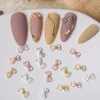 Assorted mini metallic bow nail charms in silver, gold, and rose gold tones
