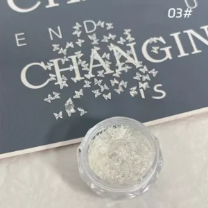 Mini butterfly holographic nail sequins scattered on flatlay background