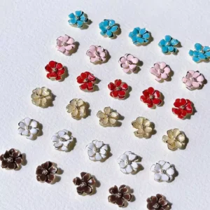 Assorted double-layer metal flower nail charms in red, gold, pink, and blue