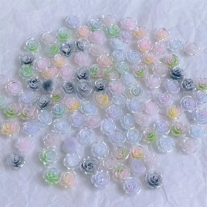 Scattered mix of resin rose nail charms on textured surface