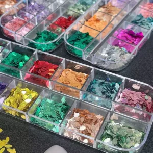 Assorted iridescent nail sequins in flower petal shapes in storage box