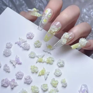 Assorted resin flower nail accessories in pastel yellow, purple, and white tones