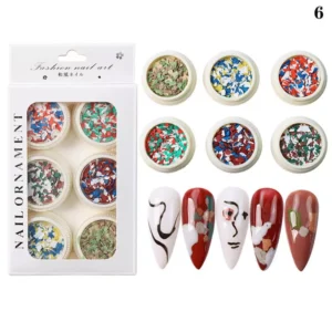 Artistic crushed flakes in bold painterly colors with red-toned modern nails