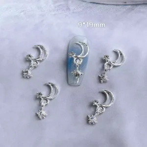 Silver moon and star nail charms on display with application sample