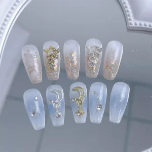 Nail art layout with applied celestial sparkle nail charms on starry and moon-themed nails