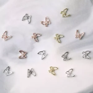 Mixed color metal butterfly nail decorations on marble background