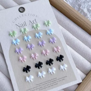 Full color set of resin bow nail charms arranged by shade on nail art collection card