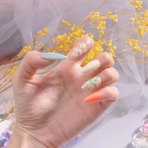 Close-up of nail art featuring glitter flakes, pastel base polish, and solid shades