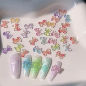 Jelly bow nail charms arranged with matching artificial nails in pastel tones