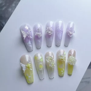 Sample nails featuring shiny flower nail charms in white and yellow resin roses