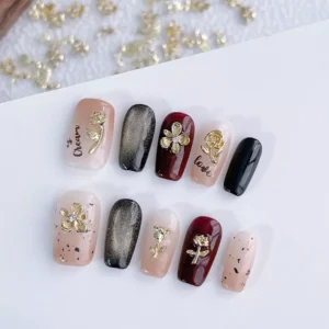 Golden floral nail art charms displayed on sample nails with matte and glossy finishes