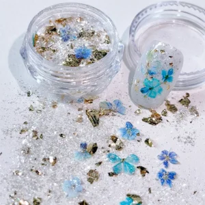 Blue pressed flowers and gold foil glitter mix in clear nail container