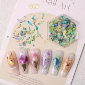 Blue-green and aqua dried flower pieces in a hex box with matching nail art
