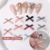Organza bow nail charms in assorted colors displayed on nude manicure