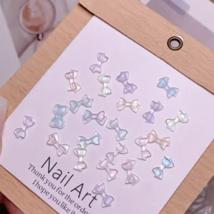 Iridescent pastel bow nail charms on display card