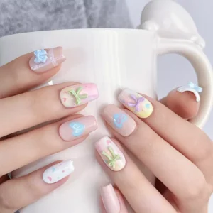 Hands holding mug with 3D pastel bow nail decorations