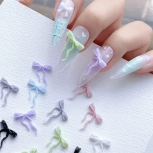 Bow ribbon nail charms in various pastel colors on elegant nails