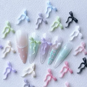 Bow ribbon nail charms in pastel colors on soft gradient nails